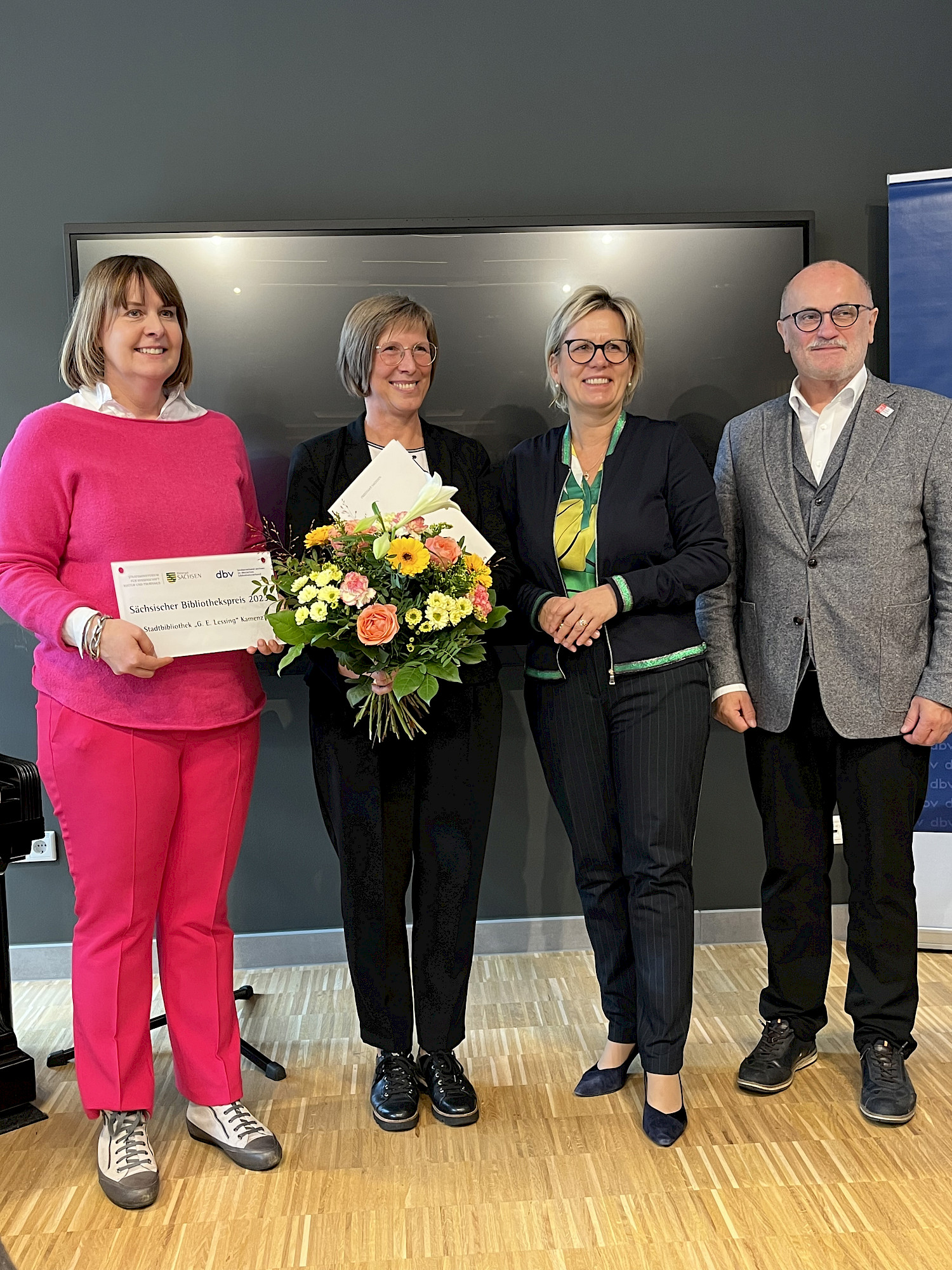 Strahlende Bibliotheksleiterin Marion Kutter mit Blumenstrauß, neben ihr Kulturministerin Barbara Klepsch und Oberbürgermeister Roland Dantz, links Aline Fiedler, Vorsitzende des Bibliotheksverbandes Sachsen